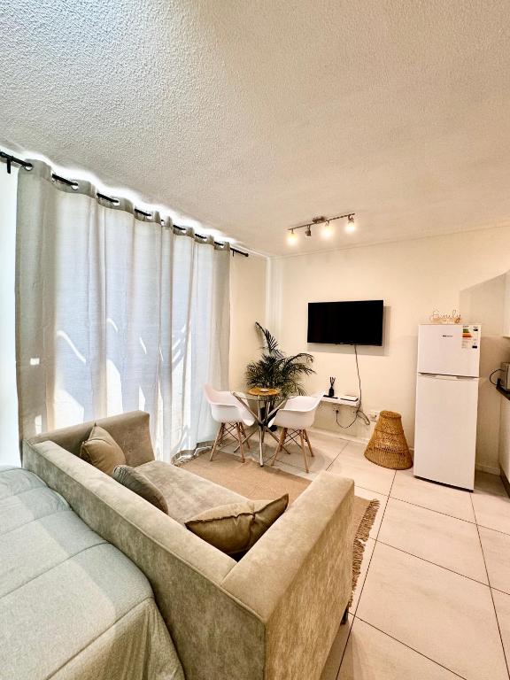 uma sala de estar com um sofá e uma mesa em CBD Studio Apartment em Windhoek