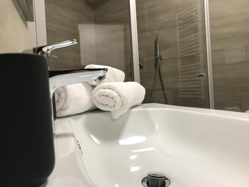 a white bathroom with towels on a sink at Casa Luca in Mezzana