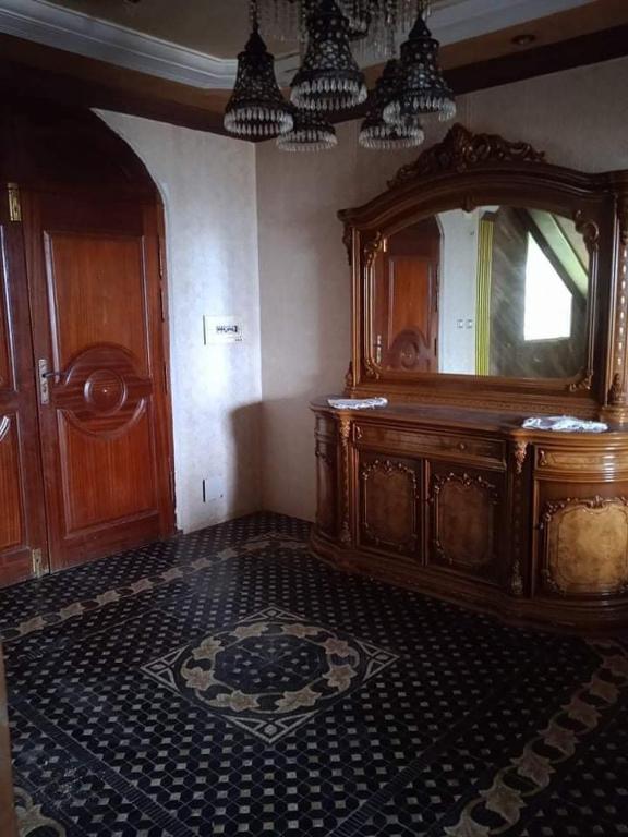 a room with a large wooden dresser and a mirror at Sousou2 in Skikda