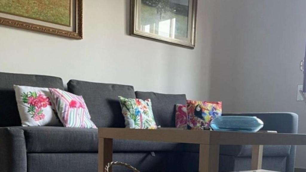 un soggiorno con divano, cuscini e tavolo di Lepanto House Positano a Positano