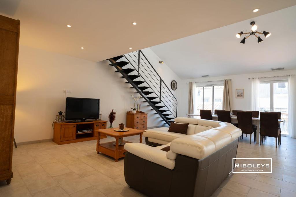 a living room with a couch and a dining room at Sublime Loft de 130m climatisé au calme in Vias