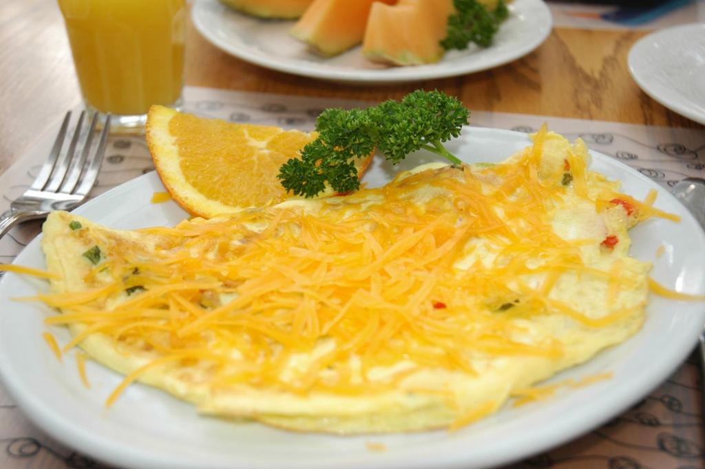 a plate of food with an omelet on a table at Douglas Guest House in Vancouver