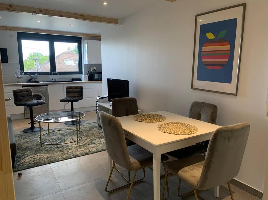 une salle à manger avec une table et des chaises dans l'établissement Bundle 2 Duplex Argenté 20 min Paris Saint Lazare, à Argenteuil