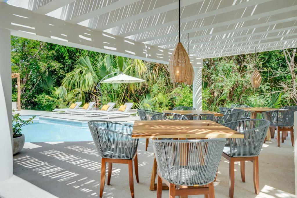 a patio with a table and chairs next to a pool at Casa Manglar Riviera Maya in Puerto Aventuras