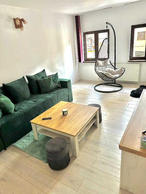 a living room with a green couch and a coffee table at Home central apartment Sibiu in Sibiu