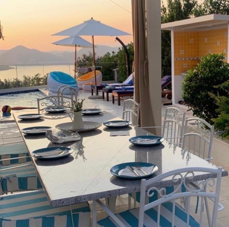 a table with chairs and an umbrella next to a pool at Villa23_Blizikuce in Blizikuće