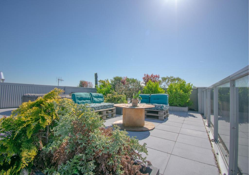 une terrasse avec 2 chaises bleues et une fontaine dans l'établissement Appartement 90m2-Roof Top privé 100m2-Parking privé-Clim mobile, à Nantes