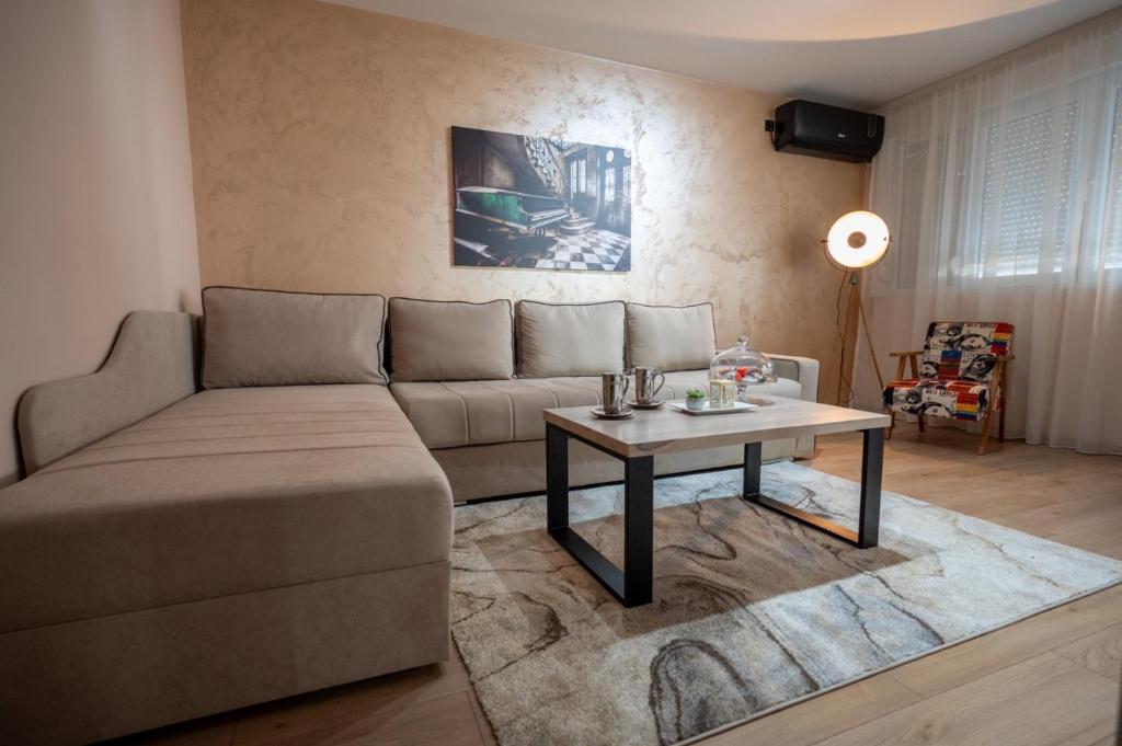 un soggiorno con divano e tavolo di Apartman Vucetic a Kraljevo