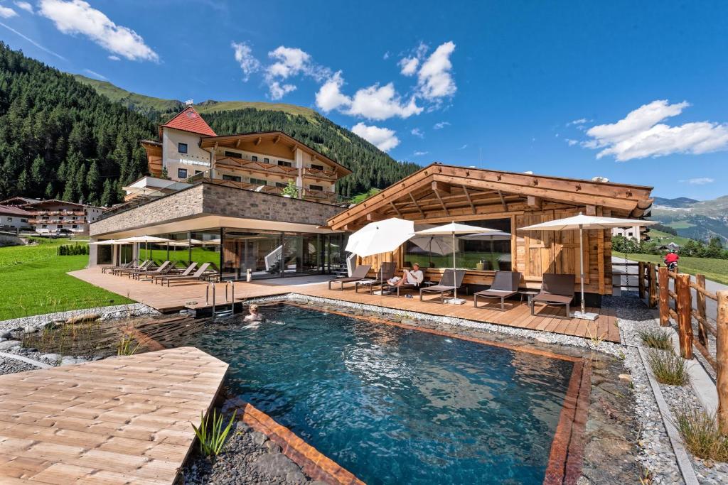 a house with a swimming pool and a building at Alpinhotel Berghaus spa in Tux