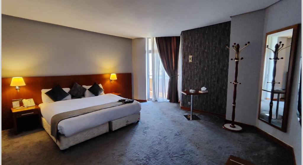 巴格達的住宿－Almansour Hotel，一间卧室设有一张大床和一个大窗户