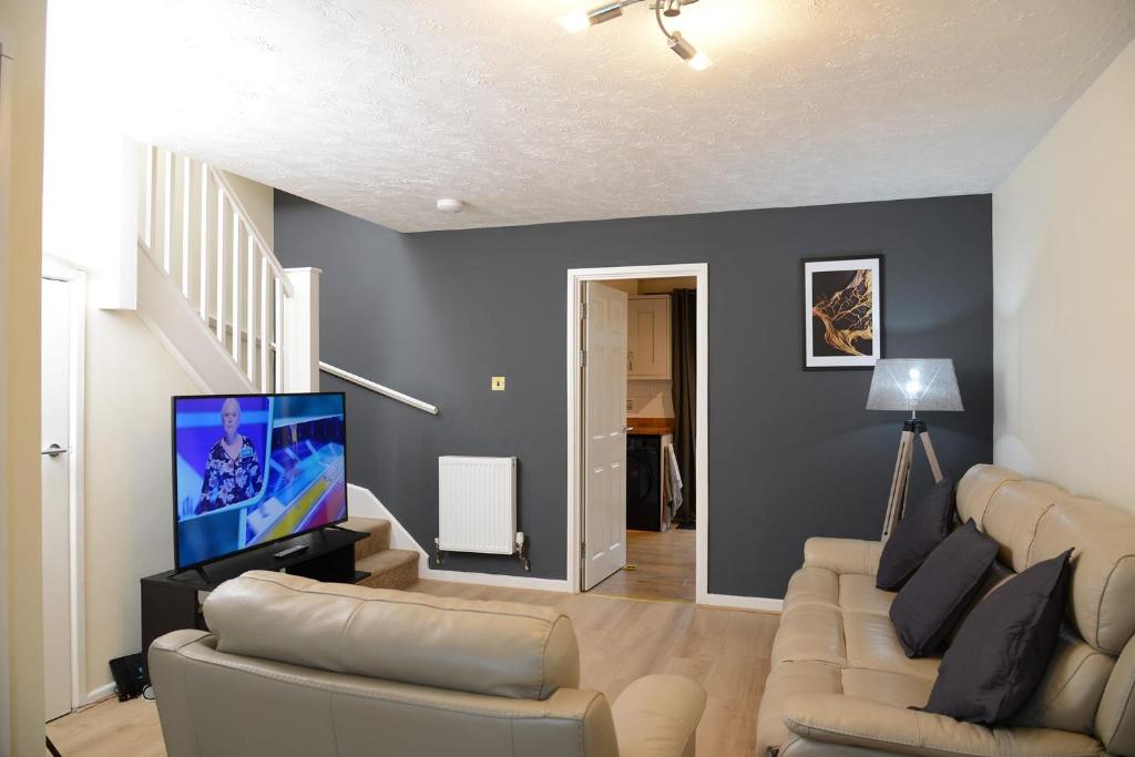 a living room with a couch and a flat screen tv at Southampton West with workspace and fast internet in Southampton