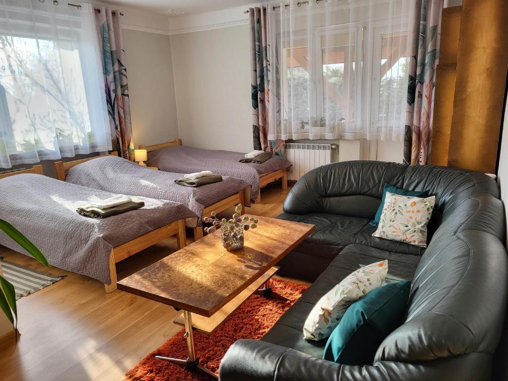 ein Wohnzimmer mit einem Ledersofa und einem Tisch in der Unterkunft Magnolia in Sobolew