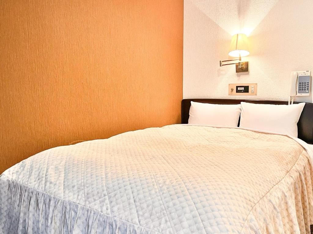 Hotel Sho Sapporo - Vacation STAY 53624v في سابورو: غرفة نوم بسرير كبير مع شراشف بيضاء