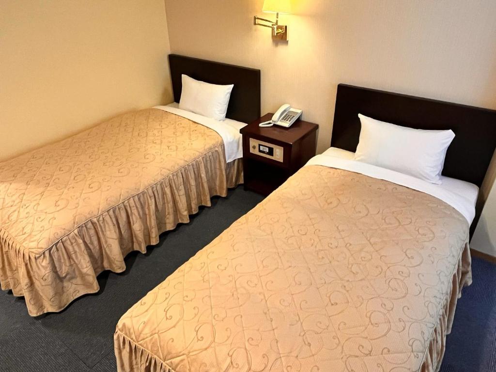 札幌市にあるHotel Sho Sapporo - Vacation STAY 61077vのベッド2台、電話が備わるホテルルームです。