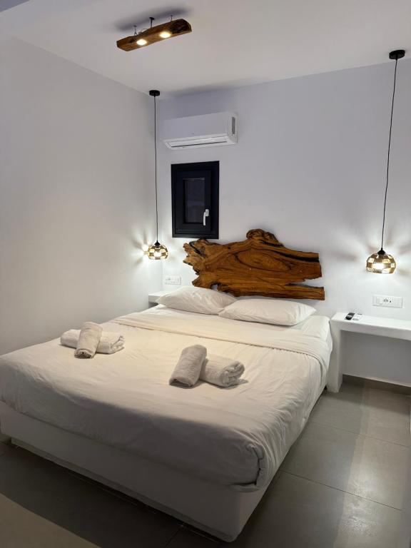 a bedroom with a large bed with two pairs of slippers at The Coast Suites in Tourlos