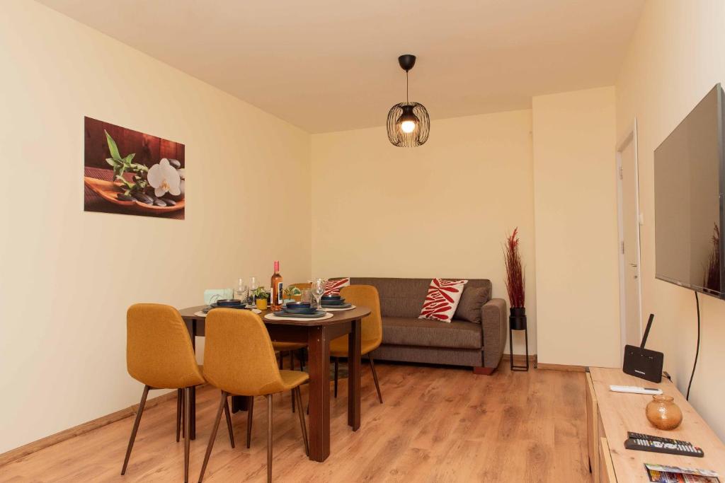 ein Wohnzimmer mit einem Tisch, Stühlen und einem Sofa in der Unterkunft Momento Apartment in Kjustendil