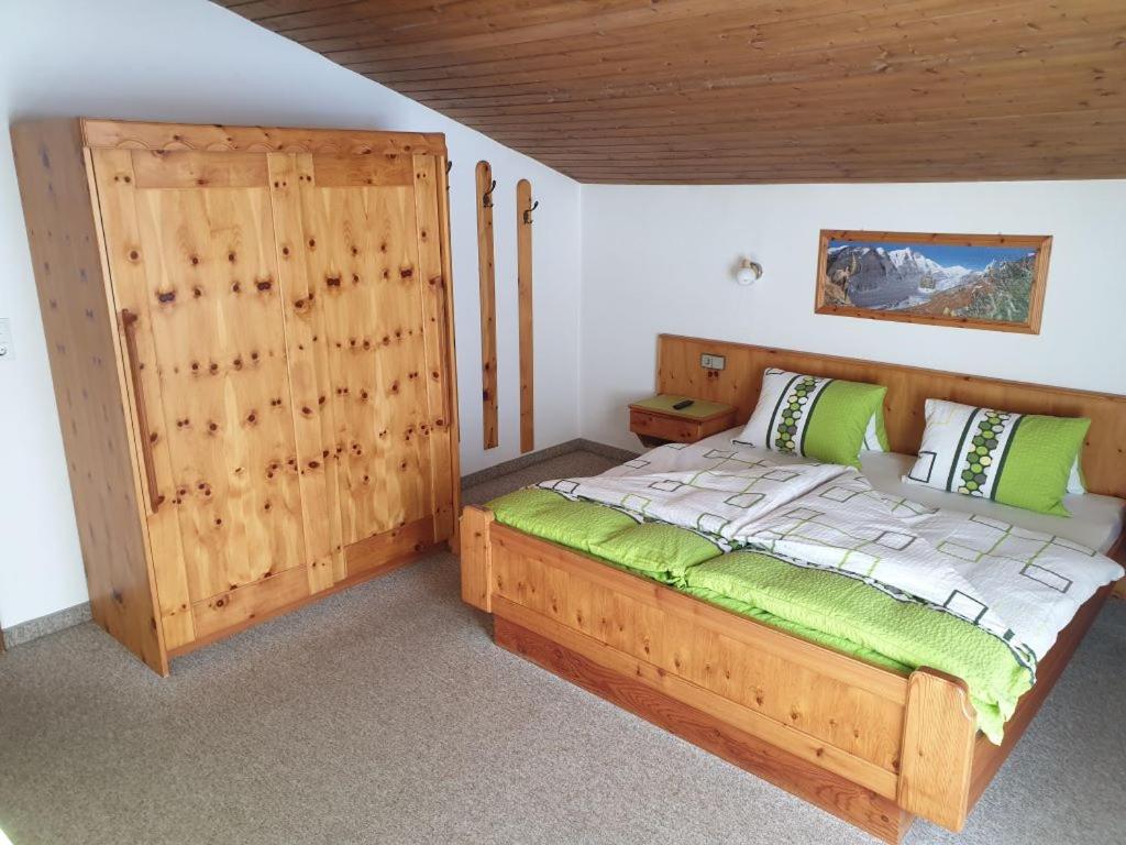 a bedroom with a wooden bed in a room at Ferienhaus Alpenblick in Heiligenblut