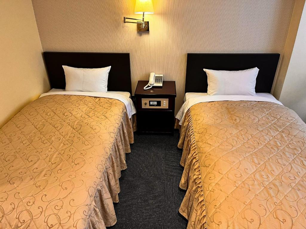 札幌市にあるHotel Sho Sapporo - Vacation STAY 61073vのベッド2台、電話が備わるホテルルームです。