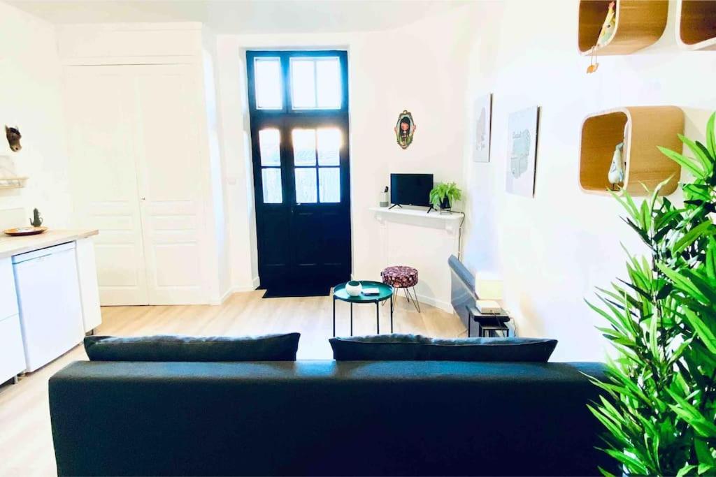 - un salon avec un canapé et une porte noire dans l'établissement Jolie maison avec jardin au calme en ville, à Limoges