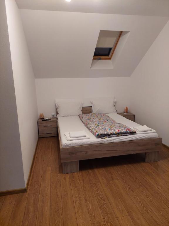 a bedroom with a bed with a wooden floor at Casa Cristina in Cârțișoara