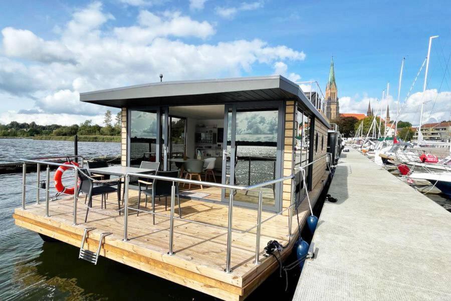 una pequeña casa en un muelle sobre el agua en Husbåt en Österhaninge