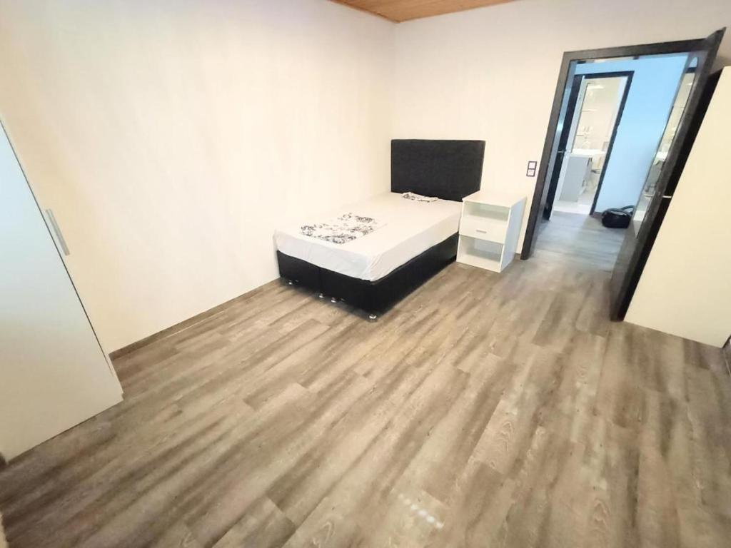 a bedroom with a bed and a wooden floor at Möblierte 5 Zimmer Wohnung in Sulzbach