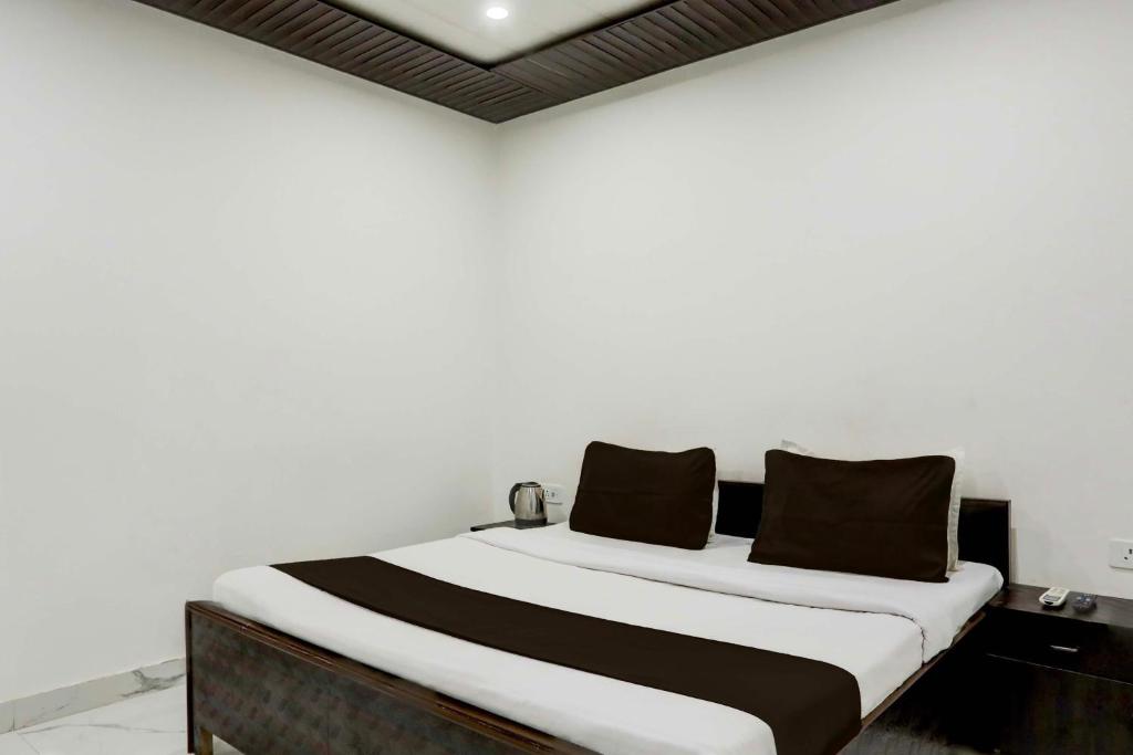 een bed met zwarte en witte lakens in een kamer bij OYO Flagship SAADAR HOTEL AND BANQUET in Kānpur