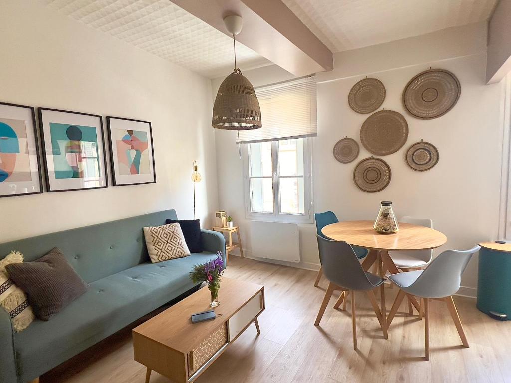 a living room with a blue couch and a table at Provins au coeur du quartier historique - Charmant studio pour 2 in Provins