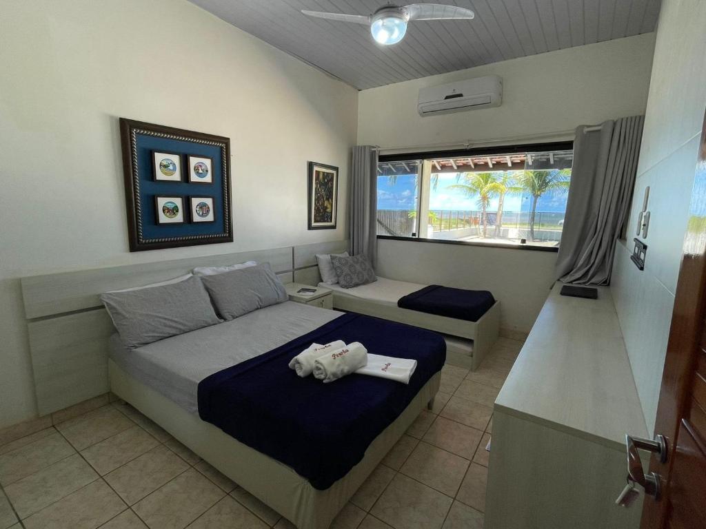 um quarto com uma cama com um bicho de peluche em Casa à Beira-mar de Peroba em Peroba