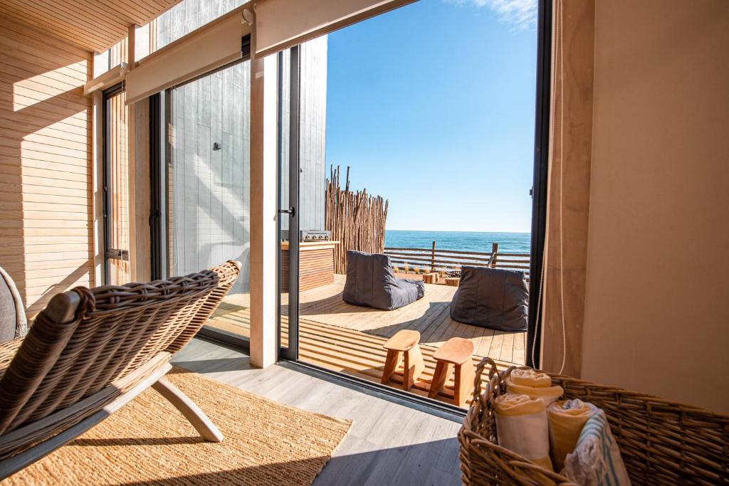 Un balcón con una silla y vistas al océano. en Casa Nek #2 Primera línea Matanzas, en Matanzas