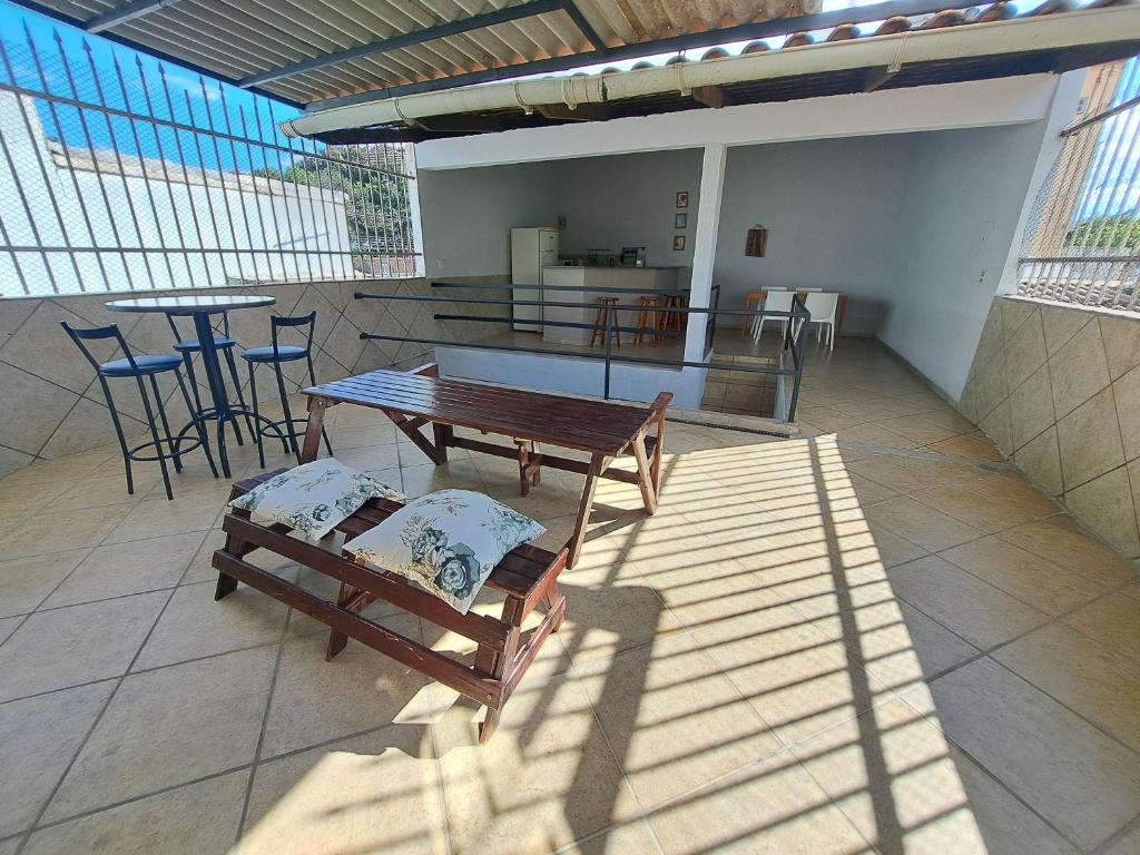 a patio with two benches and a table and a bar at Casa Grande Familia in Brasilia