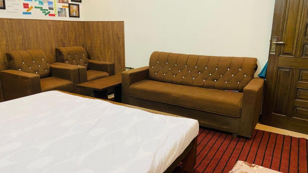 um quarto de hospital com uma cama e duas cadeiras em Gem lodges em Islamabad