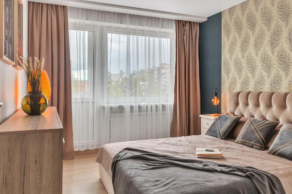 ein Schlafzimmer mit einem großen Bett und einem Fenster in der Unterkunft Tower View Apartment in Vilnius
