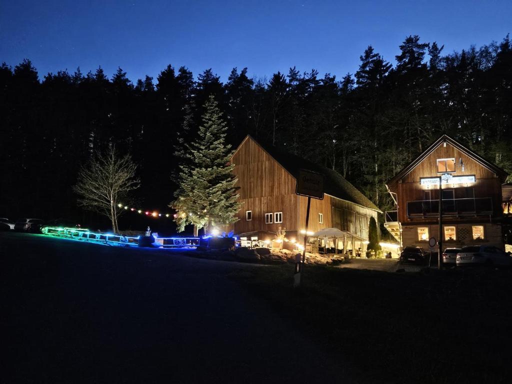 a barn at night with lights in front of it at Landgasthof Zur Linde in Kronach