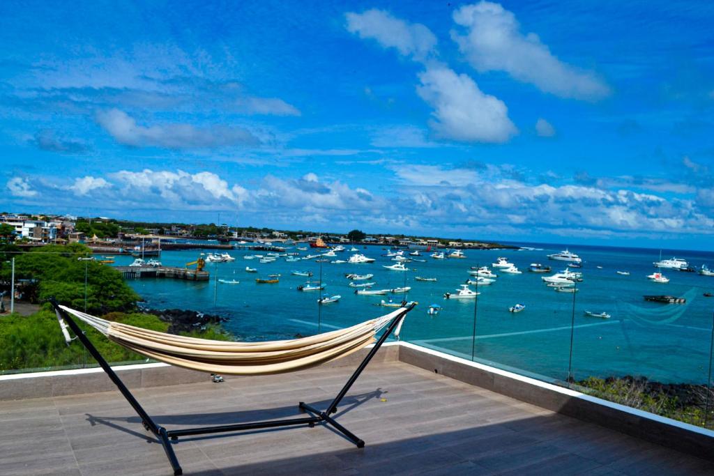 un balcón con hamaca y vistas a un puerto con barcos en SeaSide Hotel, en Puerto Baquerizo Moreno