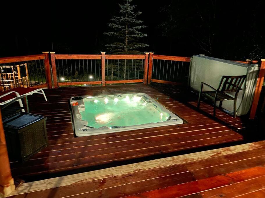 a hot tub sitting on a wooden deck at night at Where Memories Are Made in West Kill