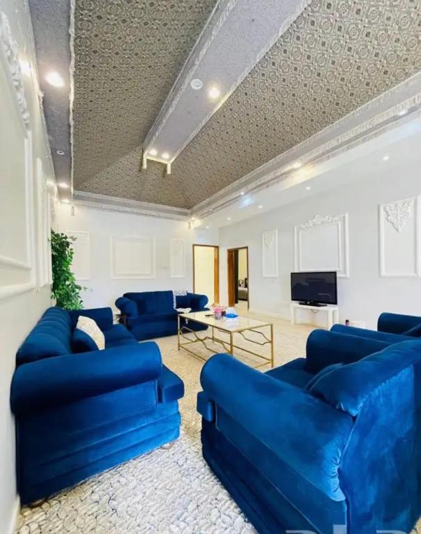 a living room with blue couches and a tv at السحاب in Abha