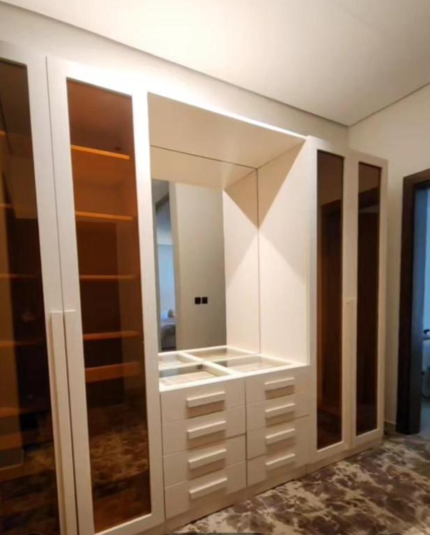 a dressing room with white cabinets and mirrors at Modern villa فلتي حديثه in Khamis Mushayt