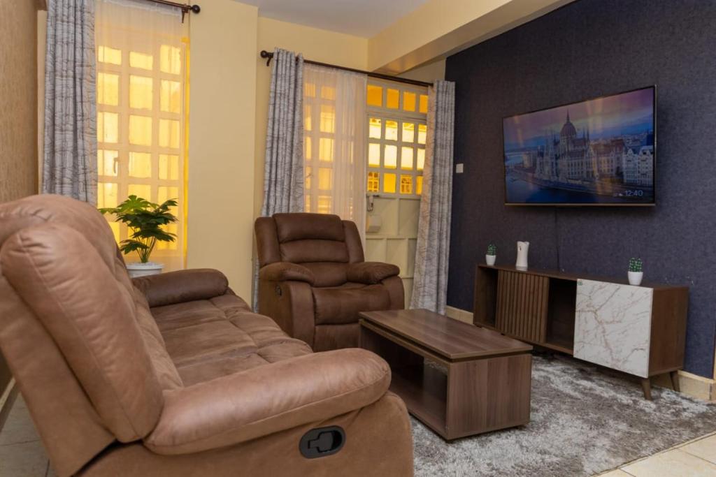 ein Wohnzimmer mit einem Sofa und 2 Stühlen in der Unterkunft Cozy kahawa sukari in Nairobi