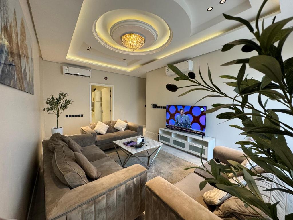a living room with a couch and a tv at شقة فاخرة ٣ غرف وصالة دخول ذاتي ٩ in Riyadh