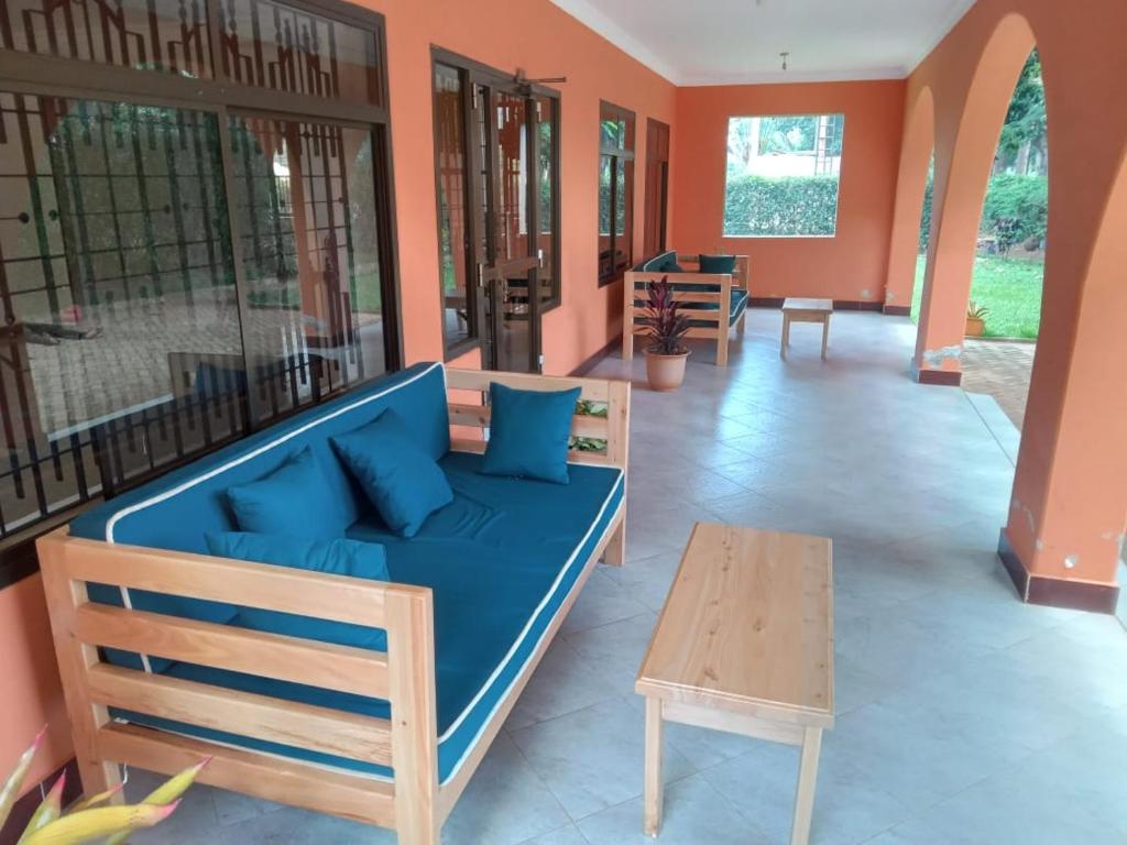 a room with a blue couch and a wooden table at J&M Hostel in Moshi