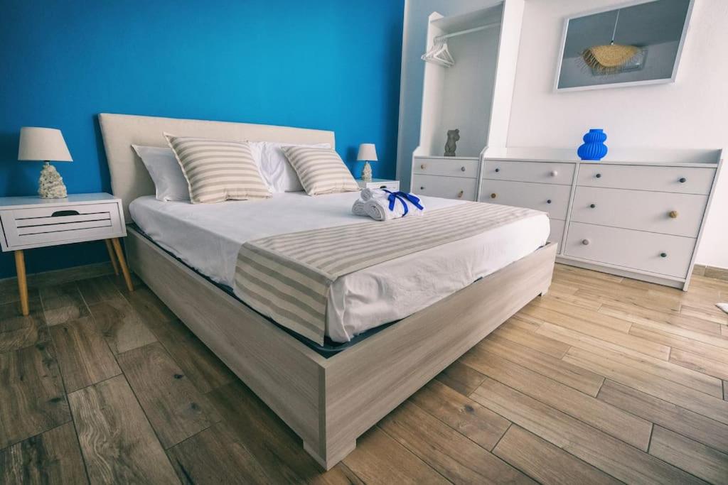 ein Schlafzimmer mit einem großen Bett und einer blauen Wand in der Unterkunft Ad un passo dal molo in Porto Torres