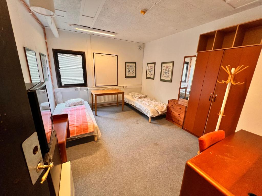 Habitación con 1 dormitorio con 2 camas y mesa. en Naffentorps Hotel en Bunkeflostrand