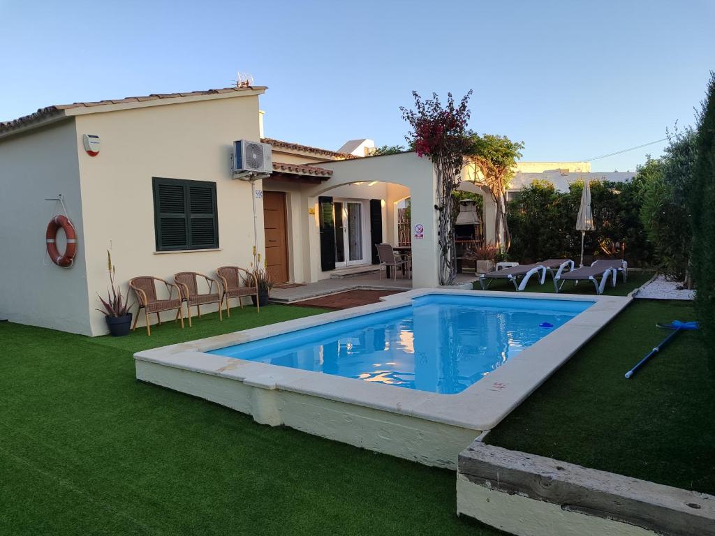 a swimming pool in a yard next to a house at Oleanda in Port d'Alcudia