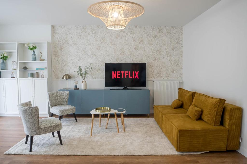 un salon avec un canapé et une télévision dans l'établissement Cozy apartment near Paris Disney - 6 min from train station, à Villiers-sur-Marne