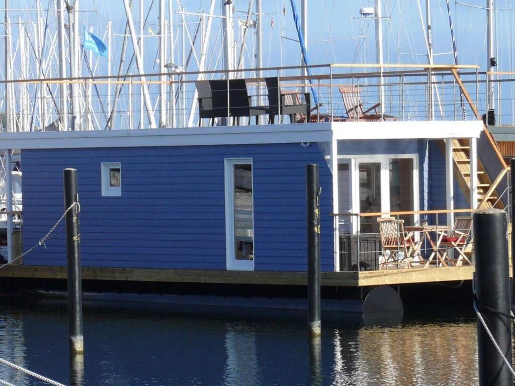 海利根港的住宿－Houseboat Lasse for family，一艘蓝色的船坐在水面上的码头上