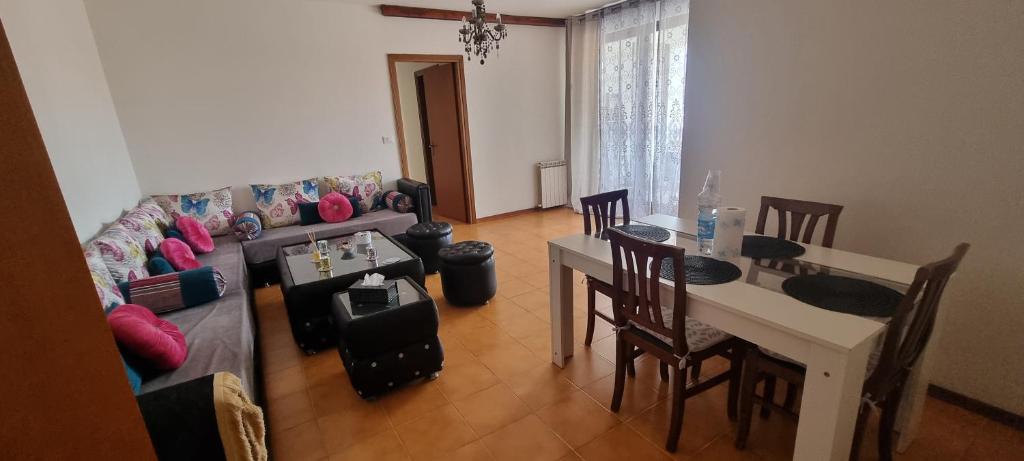 een woonkamer met een bank en een tafel en stoelen bij Sama Appartemento Butterfly in San Carlo