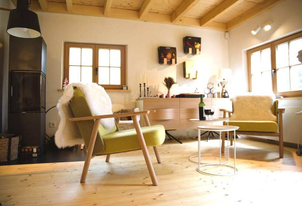 een woonkamer met een groene stoel en een tafel bij Charming Chalet with River View in Michelau