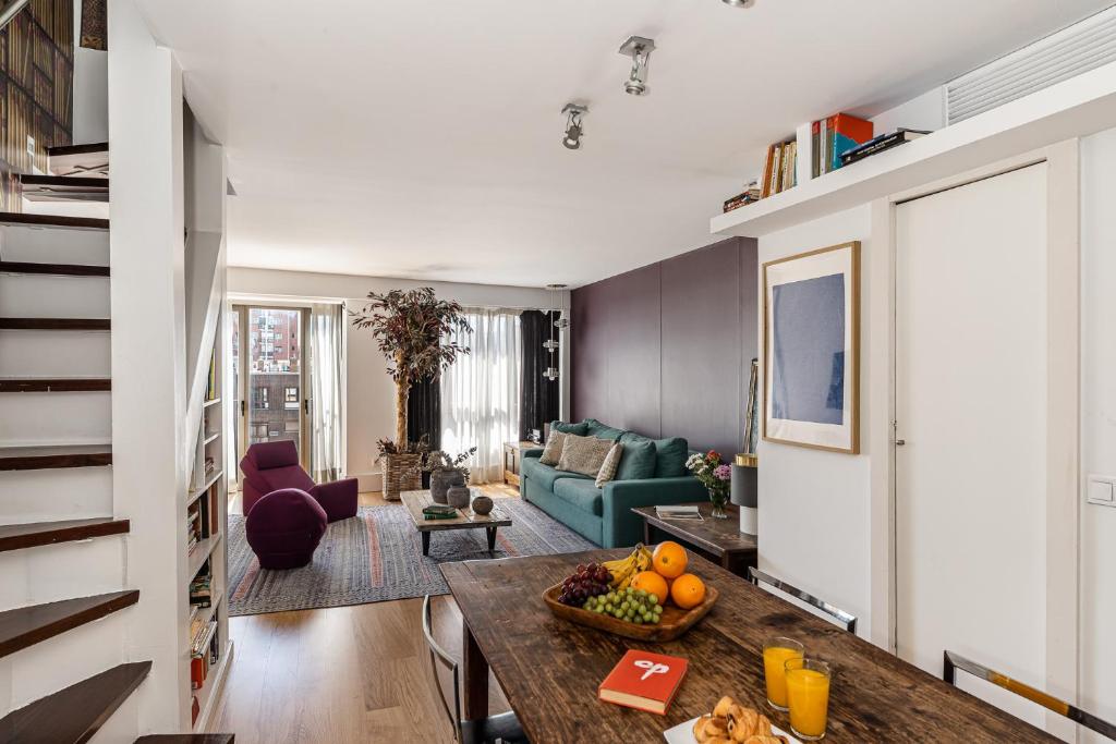 uma sala de estar com um sofá e uma mesa em BNBHolder Luxury Triplex CHAMBERI em Madri