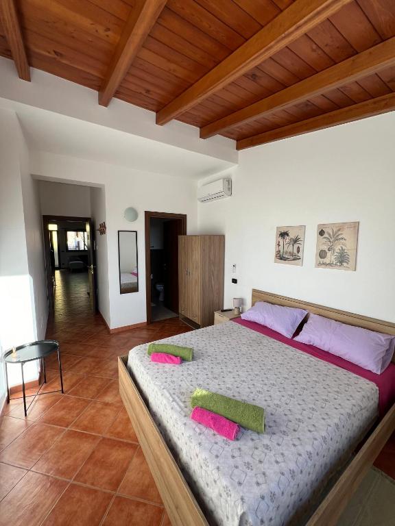 a bedroom with a large bed with pink pillows on it at Villa Alelida in Cinisi